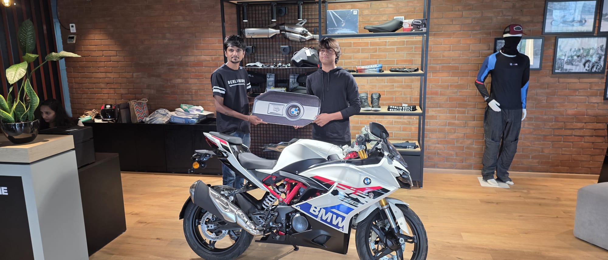 Dhruv Shukla receiving a BMW motorcycle at the showroom